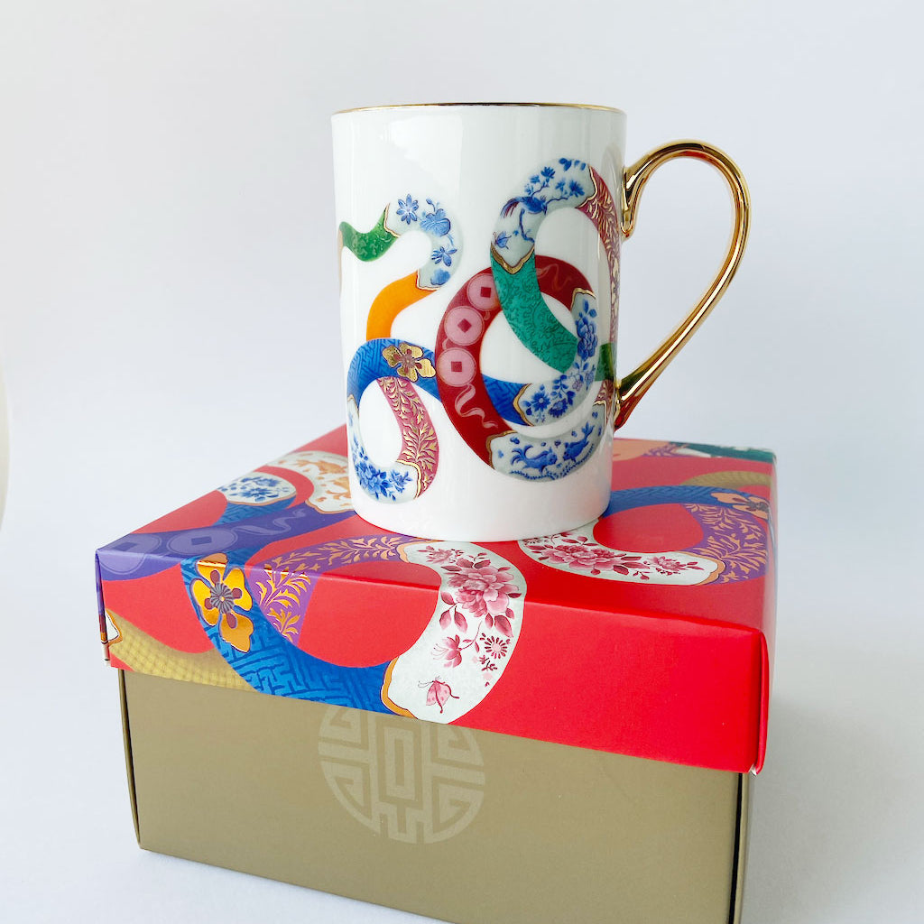 Year of the Snake fine bone china mug designed by Chris Chun, featuring a snake, carp fish, and lucky coins in intricate blue-and-white patterns with 24K gold highlights.